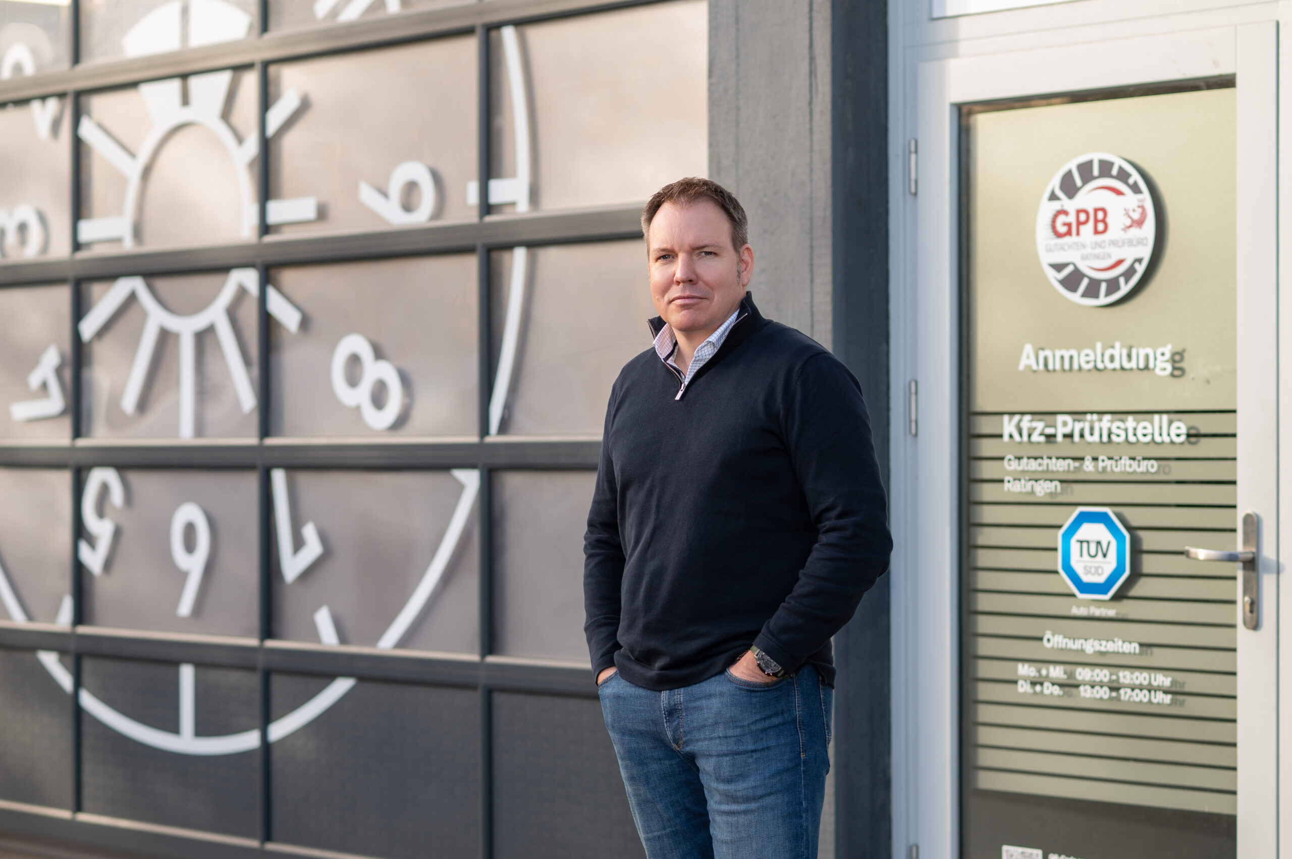 Inhaber Markus von Dollen vor dem Firmenschild der GPB Ratingen mit Tüv Süd Logo
